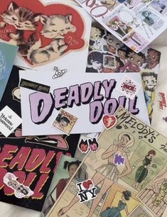 many different stickers and decals are on the table together, including one that says deadly doll