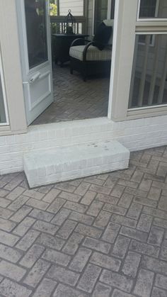 a white brick step sitting on top of a patio next to a sliding glass door