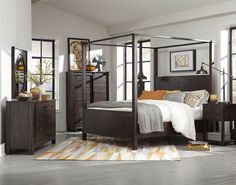 a bedroom scene with focus on the four poster bed and dresser, along with an area rug