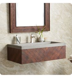 a bathroom sink sitting under a mirror next to a wooden cabinet