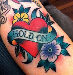 an old school style heart tattoo with the word hold on