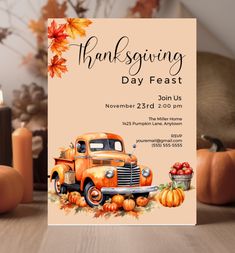 an orange truck with pumpkins on it is sitting in front of a card that says thanksgiving day feast