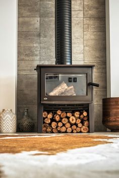 a wood burning stove with logs in front of it