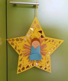 a yellow star with a paper cut out of it hanging on a green wall next to a door