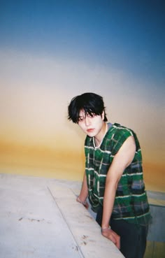 a young man standing next to a surfboard