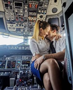 a man and woman are sitting in the cockpit of an airplane, looking at each other