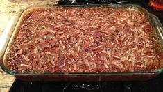 a casserole dish with pecans in it sitting on the stove top, ready to be baked