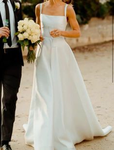 the bride and groom are walking down the beach