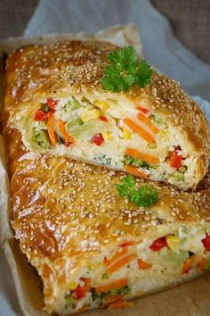 two pieces of food sitting on top of a piece of paper covered in sesame seeds