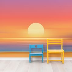 two chairs sitting next to each other in front of a wall with a sunset on it