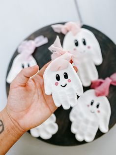 a hand is holding some fake ghost cookies