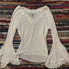 a white top with ruffled sleeves on a rug