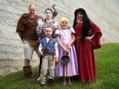 a group of people dressed up in costumes posing for a photo with one child and two adults