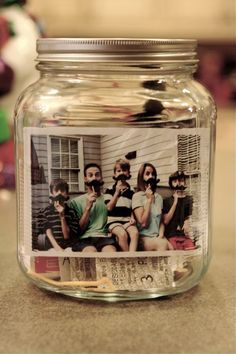 a glass jar filled with pictures of people sitting in front of a window on top of a table