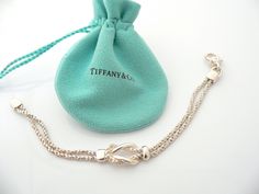 Do you know which items made Tiffany a world renowned company? You just stumbled upon one of them! Offered for sale is a wonderful vintage Tiffany and Co. Sterling Silver Double Rope Love Knot bracelet - in a rare longer length - 7.75 inches. The piece is made from solid and substantial Tiffany silver, yet has a very delicate and feminine feel to it. The bracelet is very unique - hard to find and come by, so grab it while you have the chance! It is very pretty worn on its own, but would also wor Luxury Chain Bracelet With Sterling Silver Clasp As Gift, Timeless Bracelet With Lobster Clasp For Gift, Timeless Bracelets With Lobster Clasp For Gift, Elegant Chain Bracelet With Clasp As Gift, Engraved Chain Bracelet For Formal Occasions, White Gold Jewelry With Clasp For Gift, Elegant Silver Bracelet With Hallmarks, Vintage Sterling Silver Clasp Chain Bracelet Gift, Vintage Chain Bracelet With Sterling Silver Clasp As Gift