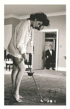 an old photo of a woman playing golf in her living room with two men watching