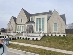 a large white brick house with landscaping in front