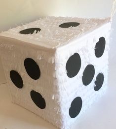 a white box with black dots on the side and two holes in the front that have been made to look like dices