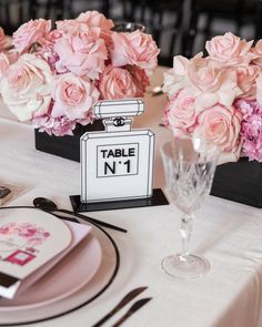 there is a table set with pink flowers and place cards