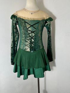 a green dress with laces on the shoulders and back, sitting on a mannequin