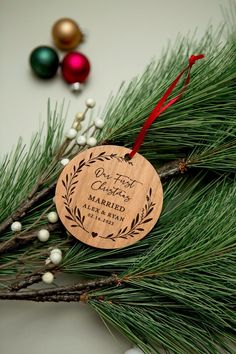 a wooden ornament hanging from a christmas tree branch with ornaments around it and the words, best wishes married to each other