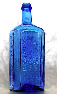 a blue glass bottle sitting on top of a table