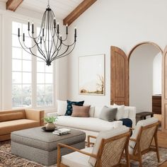 a living room filled with lots of furniture and a chandelier hanging from the ceiling