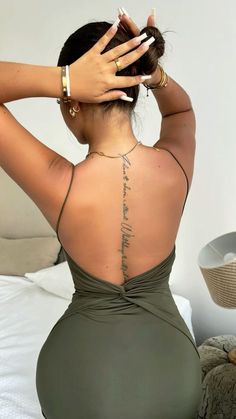 the back of a woman's body with tattoos on it