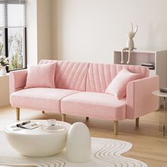 a living room with a pink couch and coffee table