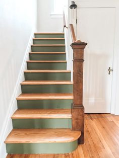 a set of wooden stairs leading up to a white door