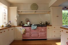 a pink stove top oven sitting inside of a kitchen