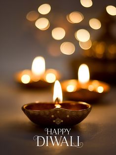 lit candles with the words happy diwali written in white and gold on it