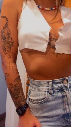 a woman with tattoos on her arm and chest