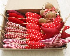 a box filled with lots of red and white cloth dolls sitting on top of a wooden table