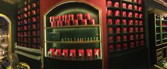 a room filled with lots of red and black shelves full of bottles on top of each other