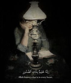 a person sitting at a table with a lamp in front of them and an arabic quote on it