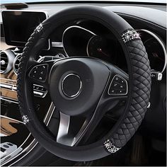 the steering wheel cover is decorated with silver beads and black stitching on it's center console