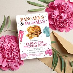 there is a birthday card with pancakes and pajamas on it next to pink carnations