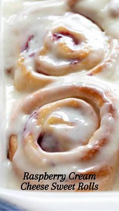 raspberry cream cheese sweet rolls with icing in a white casserole dish