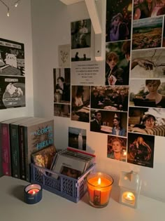 a table topped with books and candles next to pictures