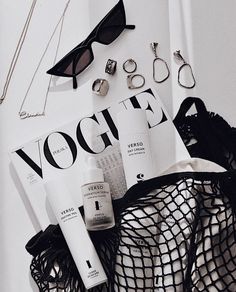 the contents of a black and white bag including sunglasses, eyeglasses, hair products