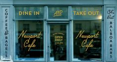 the front window of a restaurant that has been painted blue with gold lettering on it