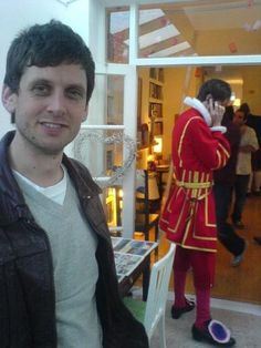 a man standing in front of a store talking on a cell phone while wearing a costume