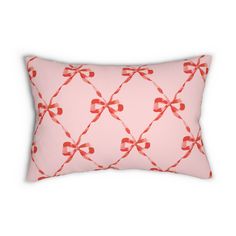 a pink pillow with red bows and hearts on it's side, against a white background