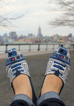 someone's feet wearing star wars shoes with the city in the background