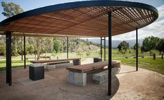 an empty park with benches under a covered area