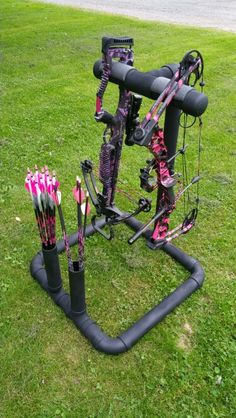 an assortment of archery bows and arrows in the grass