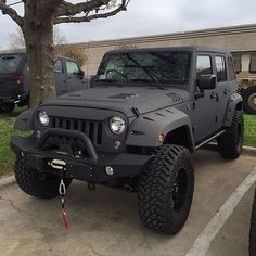 a gray jeep parked in a parking lot