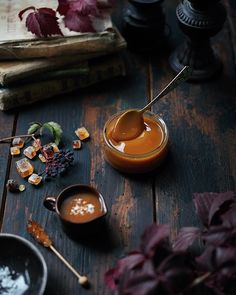 a spoon with some liquid in it on a table next to books and other items