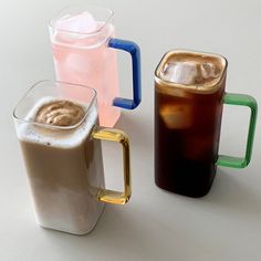 there are three different types of drinks on the table, one is brown and one is iced